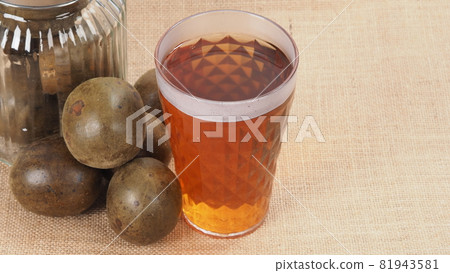 Monk fruit or Luo Han Guo. Dried fruits for healthy sweetener drink. Natural herbal remedy and glass bottle background. Monk fruit drink for who concern health and sugar substitute. Monk fruit or Luo Han Guo. Dried fruits for healthy sweetener drink. Natural herbal remedy and glass bottle background. Monk fruit drink for who concern health and sugar substitute. 81943581