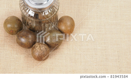 Monk fruit or Luo Han Guo. Dried fruits for healthy sweetener drink. Natural herbal remedy and glass bottle background. Monk fruit drink for who concern health and sugar substitute. 81943584
