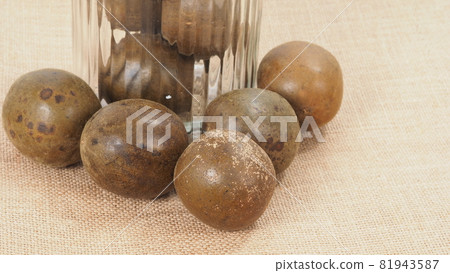 Monk fruit or Luo Han Guo. Dried fruits for healthy sweetener drink. Natural herbal remedy and glass bottle background. Monk fruit drink for who concern health and sugar substitute. 81943587