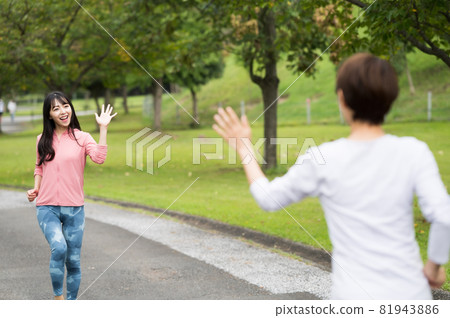 Two women waving their hands while jogging 81943886