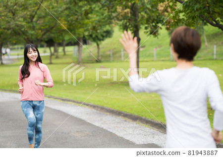Two women waving their hands while jogging Two women waving their hands while jogging 81943887