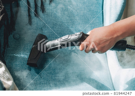 Hand cleaning a armchair with steam cleaner, Home cleaning conce Hand cleaning a armchair with steam cleaner, Home cleaning conce 81944247
