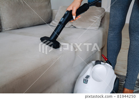 Hand cleaning a sofa with steam cleaner, Home cleaning concept. Hand cleaning a sofa with steam cleaner, Home cleaning concept. 81944250