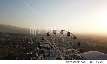 Ferris wheel on the green hill Kok Tobe at sunset Ferris wheel on the green hill Kok Tobe at sunset 81945368