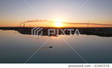 The boat sails in the bay at sunset near the city The boat sails in the bay at sunset near the city 81945578