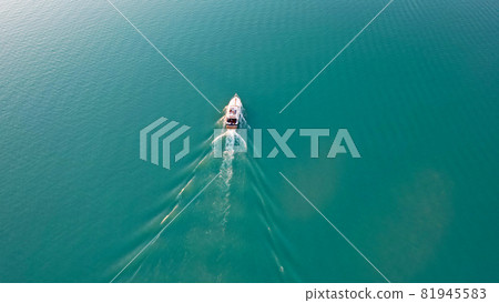 The boat sails on Lake Balkhash at sunset. 81945583