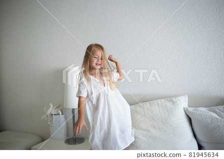 little cute girl jumping on the bed in the bedroom little cute girl jumping on the bed in the bedroom 81945634