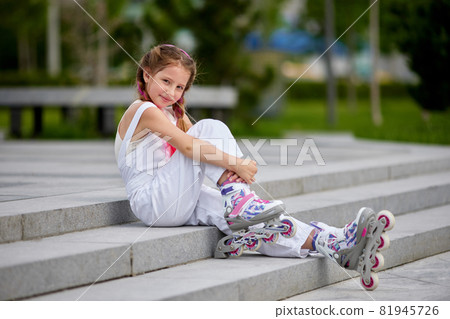 cute little girl on roller skates at park. cute little girl on roller skates at park. 81945726