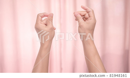 Hands snapping fingers isolated on pink background. Isolated female hands flicking fingers to the rhythm of the music. Sign language. 81948161
