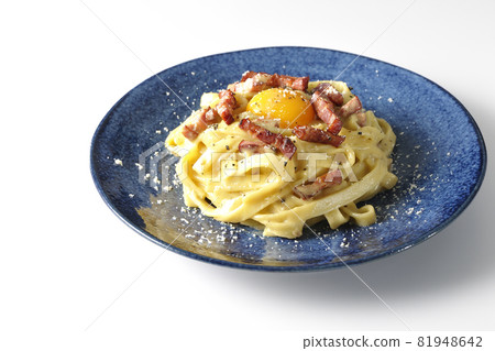 Photographed Fettuccine carbonara with egg yolk and crispy bacon on a white background Photographed Fettuccine carbonara with egg yolk and crispy bacon on a white background 81948642