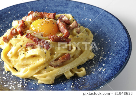 在白色背景上拍攝了帶有蛋黃和脆培根的 Fettuccine carbonara 81948653