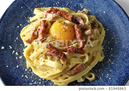 A bird's-eye view of Fettuccine's carbonara with egg yolk and crispy bacon on a white background 81948863