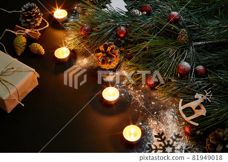 Christmas. Xmas toys, burning candles and spruce branch on black background top view. Space for text 81949018