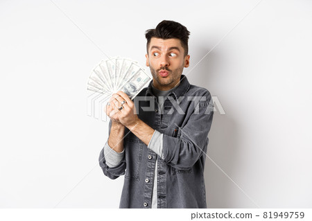 Excited man hugging and kissing dollar bills, holding money and rejoicing, standing on white background 81949759