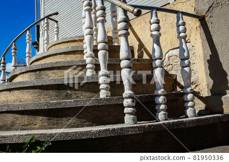 Round stairs with artistic railings bottom up view going upwards to the blue sky 81950336