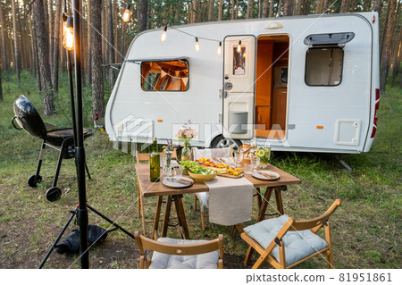 Served table with chairs around standing against house on wheels Served table with chairs around standing against house on wheels 81951861