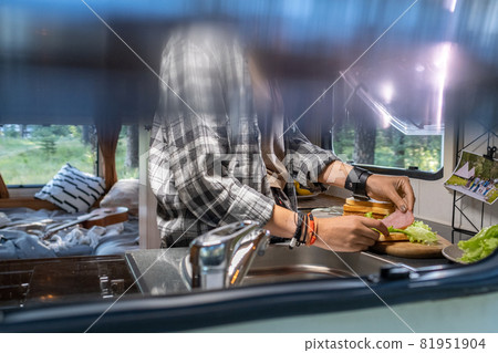 Hands of young femle preparing sandwiches inside house on wheels Hands of young femle preparing sandwiches inside house on wheels 81951904
