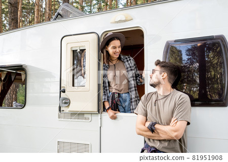 Happy young dates looking at one another by house on wheels Happy young dates looking at one another by house on wheels 81951908