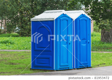 Two blue plastic toilet cabins. Public toilets in the city park. Two blue plastic toilet cabins. Public toilets in the city park. 81953472
