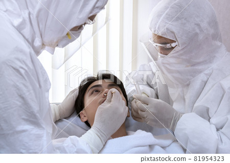 male nurse and doctor wearing ppe suit and facemask perform Coronavirus COVID-19 PCR test. patient nasal NP and oral OP swab sample specimen collection process, viral rt-PCR DNA diagnostic procedure. 81954323