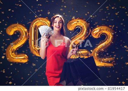Woman with dollars and purchases. New Year shopping. Black Friday. 2022 balloons. sales. Celebrate Woman with dollars and purchases. New Year shopping. Black Friday. 2022 balloons. sales. Celebrate 81954417