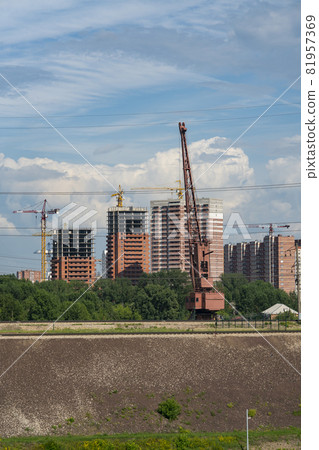 Large red harbor crane on the background of an industrial city. Large red harbor crane on the background of an industrial city. 81957369
