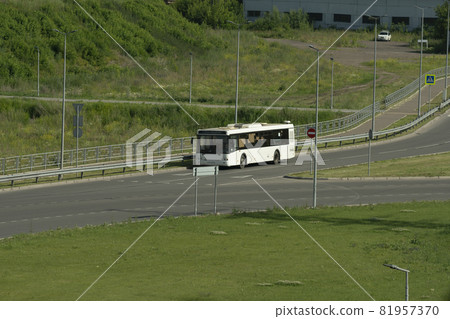 White passenger bus on a country road on a summer day. White passenger bus on a country road on a summer day. 81957370