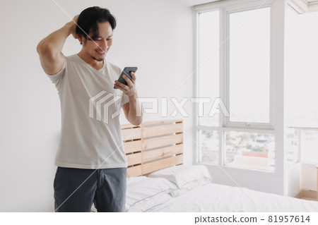 Happy man greeting online friends in the smartphone. Happy man greeting online friends in the smartphone. 81957614