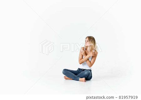 pretty blonde in jeans sitting on the floor isolated background pretty blonde in jeans sitting on the floor isolated background 81957919