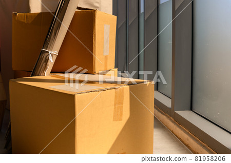 stack of Cardboard near big window inside of modern living room 81958206