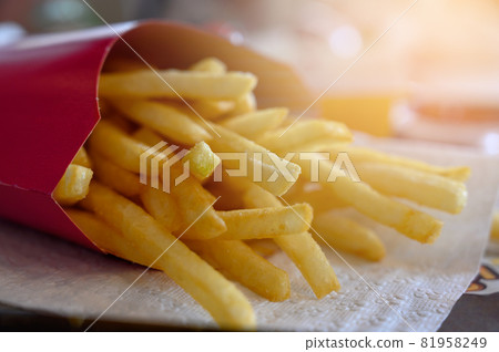 french fries in red paper bag on white paper. Potatoes fries in fast food restaurant french fries in red paper bag on white paper. Potatoes fries in fast food restaurant 81958249