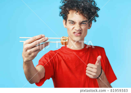 man in red t-shirt curly hair dry snack japanese fast food man in red t-shirt curly hair dry snack japanese fast food 81959383