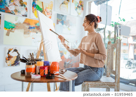 asian female artist painting on canvas doing some art projects on her studio workshop 81959465