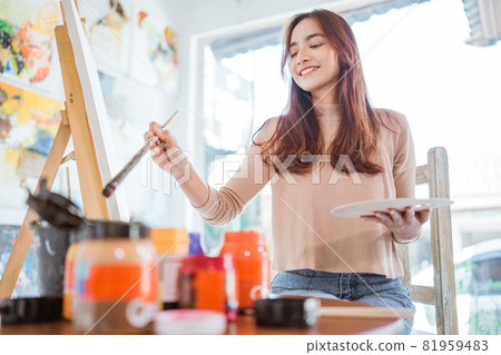 asian female artist painting on canvas doing art projects on her studio asian female artist painting on canvas doing art projects on her studio 81959483