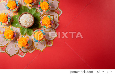 Happy Dussehra. Yellow flowers, green leaf and rice on red background. Dussehra Indian Festival concept. Happy Dussehra. Yellow flowers, green leaf and rice on red background. Dussehra Indian Festival concept. 81960722