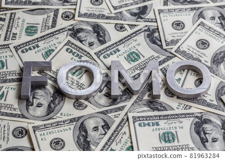 The word FOMO laid with aluminium letters on the US dollar banknotes background - with selective focus The word FOMO laid with aluminium letters on the US dollar banknotes background - with selective focus 81963284