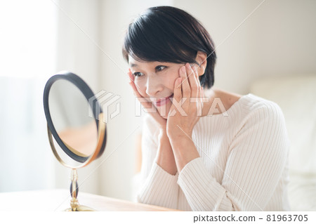 優雅的女士對著鏡子做護膚 優雅的女士對著鏡子做護膚 81963705