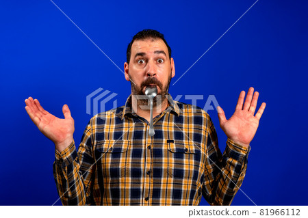 Close-up portrait of attractive skeptic minded guy licking spoon healthy menu nutrition isolated over bright blue color background 81966112