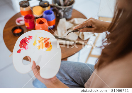 close up of female painters hand holding a paint brush close up of female painters hand holding a paint brush 81966721