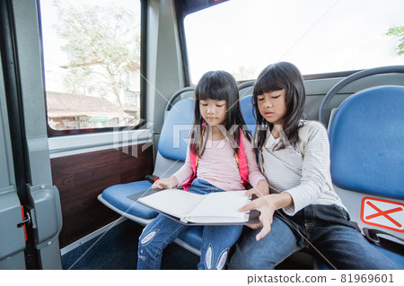 two asian primary student going to school by bus public transport 81969601