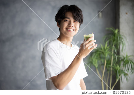 Young man drinking a smoothie Young man drinking a smoothie 81970125