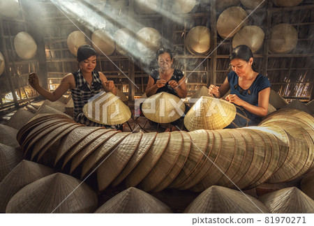 Group of Vietnamese female craftsman making the traditional vietnam hat in the old traditional house in Ap Thoi Phuoc village, Hochiminh city, Vietnam, traditional artist concept 81970271