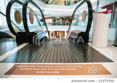 Always Practice Social Distancing Text with thai and chinese language with the same meaning on the floor before escalator in department store Always Practice Social Distancing Text with thai and chinese language with the same meaning on the floor before escalator in department store 81970390
