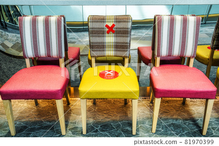 Do NOT SIT SOCIAL DISTANCING Text on the waiting chair in front of restaurant or coffee shop in department store Do NOT SIT SOCIAL DISTANCING Text on the waiting chair in front of restaurant or coffee shop in department store 81970399