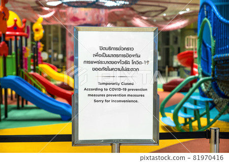 Temporarily Closed Text with thai and chinese language with the same meaning over the billboard in front of amusement park in department store.. Temporarily Closed Text with thai and chinese language with the same meaning over the billboard in front of amusement park in department store.. 81970416