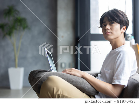 Young man looking at a computer in the room 81970455