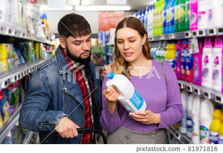 couple chooses household chemicals in supermarket 81971816