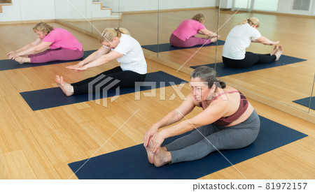 Women making yoga at gym. Paschimottanasana pose 81972157