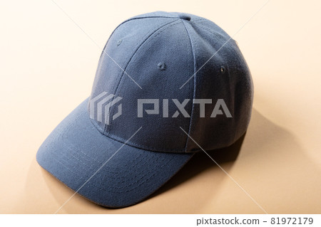 Composition of traditional peaked grey baseball cap on pale brown background 81972179