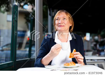 Mature woman enjoying coffee in cafe 81973046
